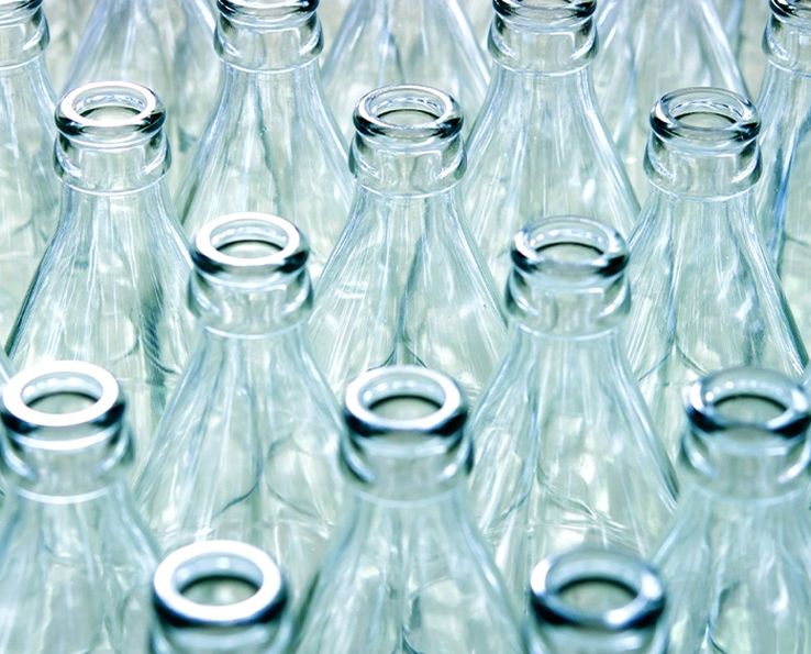 Bouteilles en verre transparentes rangées sur un fond clair