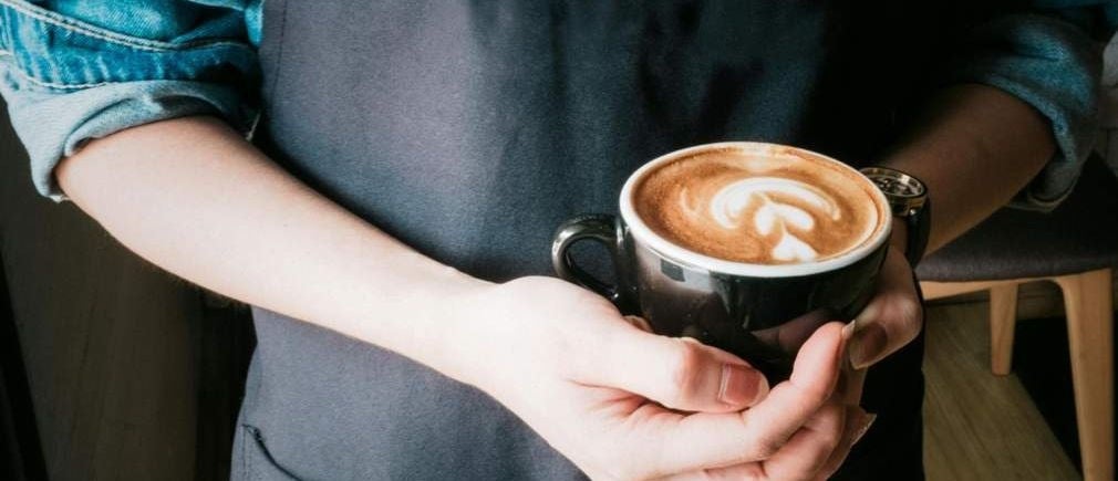 Barista tient une tasse de latte art