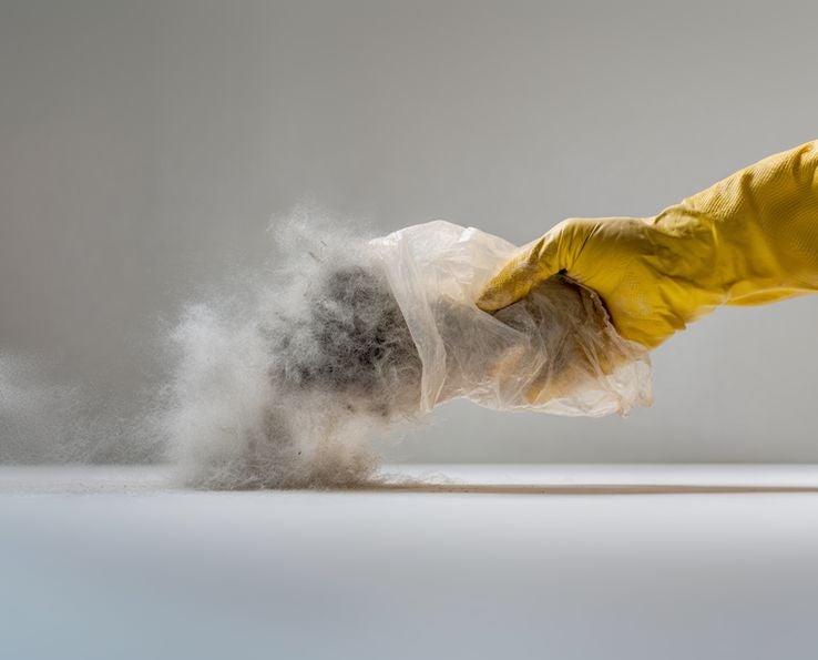 Gant en latex tenant un sac aspirateur pour poussière en aperçu social