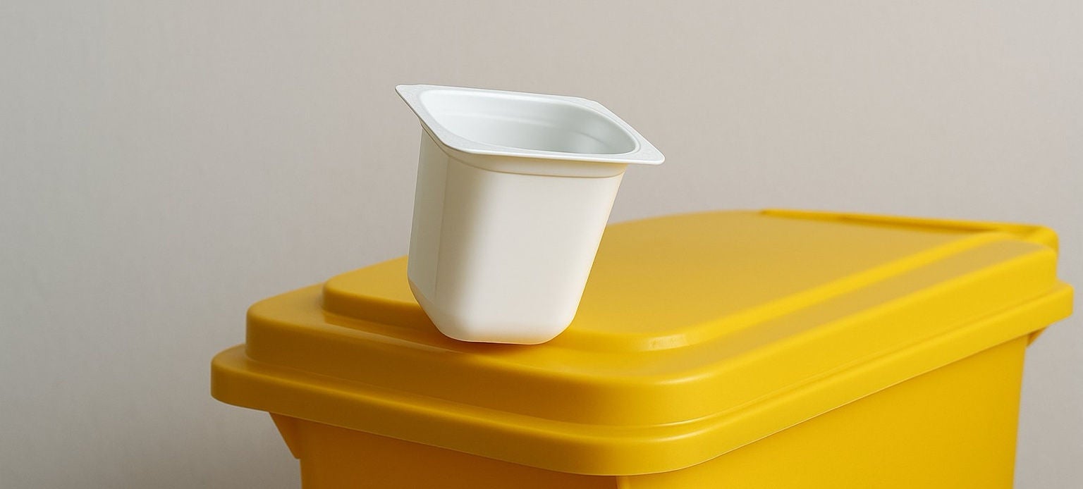 Pot en plastique blanc posé sur un sac poubelle jaune