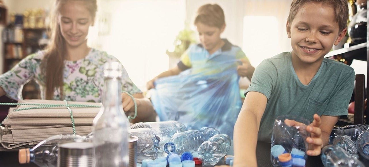 Enfants triant des déchets plastiques et en carton avec un sac poubelle Handybag