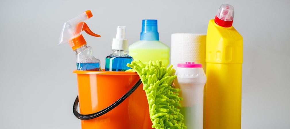 Seau orange contenant des produits d’entretien, chiffon vert et vaporisateur