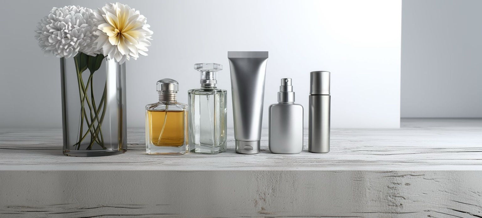 Vase avec fleurs et flacons de parfum minimalistes sur fond épuré