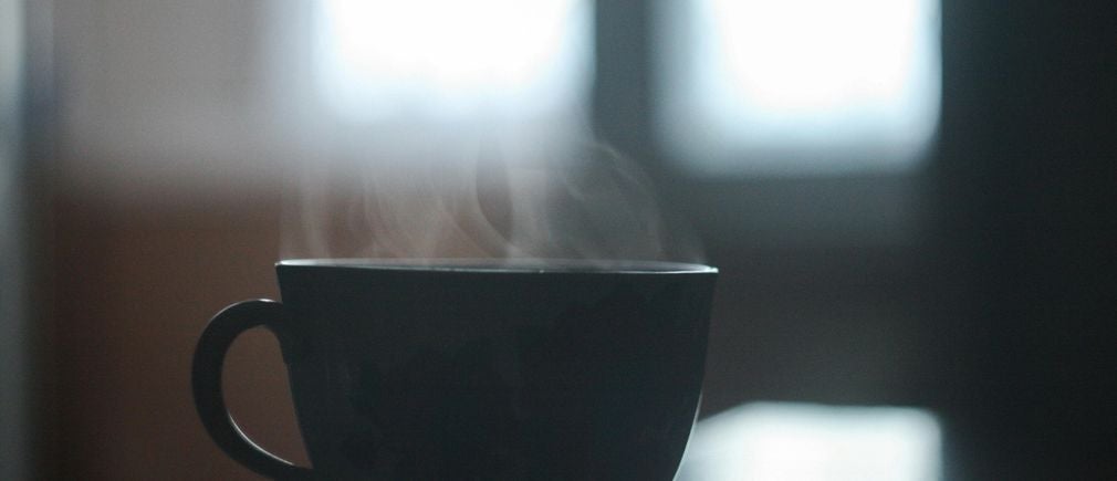 Tasse de thé fumante devant une fenêtre pour une ambiance conviviale
