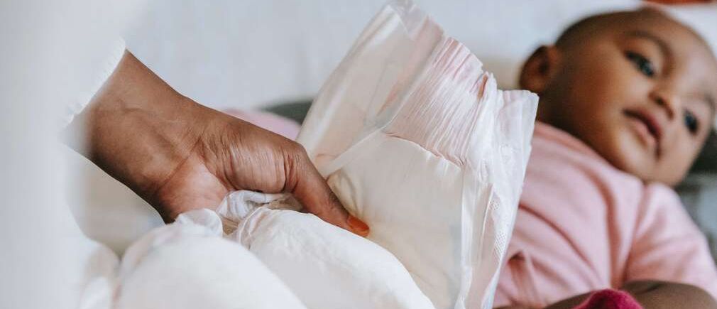 Bébé en train de changer sa couche sur un lit