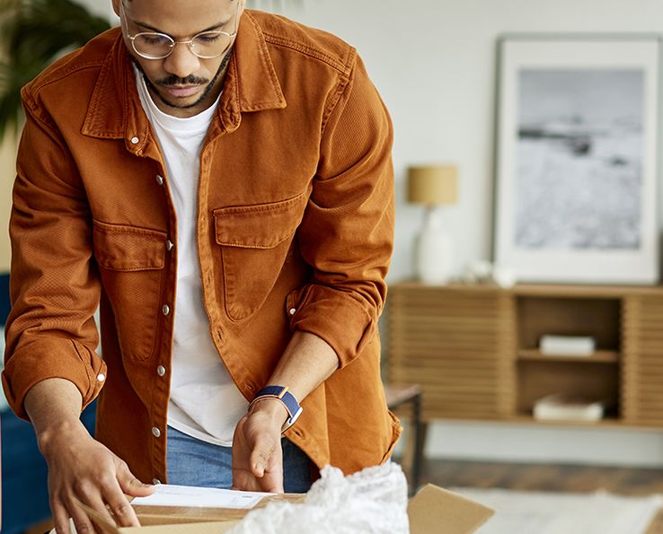 Homme préparant des cartons de déménagement dans un salon