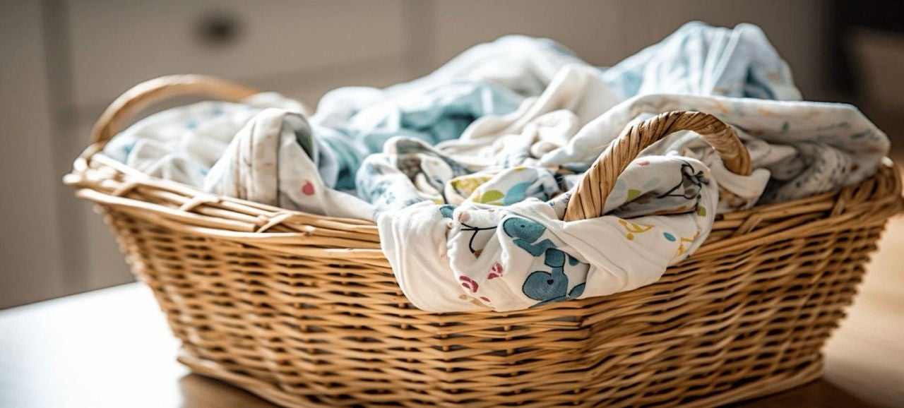 Panier en osier rempli de linge de bébé blanc et bleu