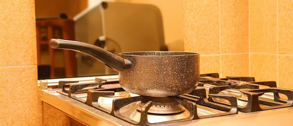Casserole renforcée posée sur un feu à gaz dans une cuisine