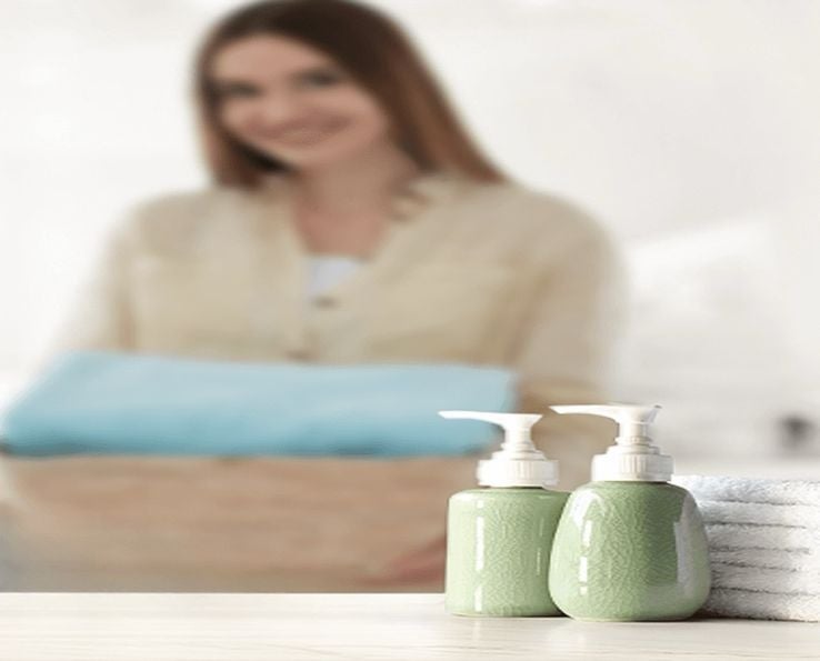 Flacons de shampoing vert sur fond flou avec une femme