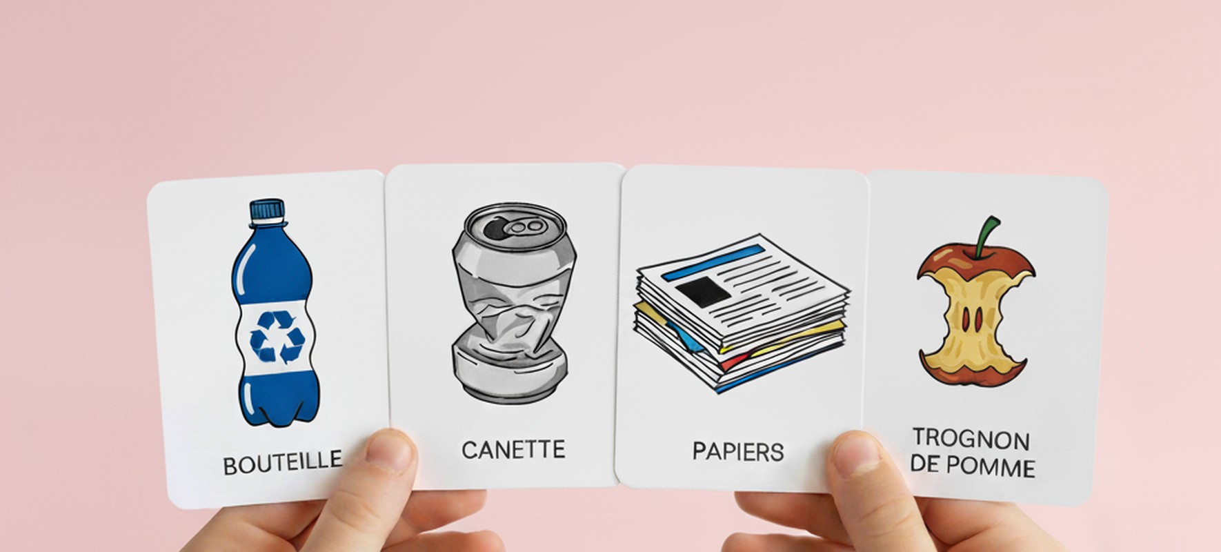 Deux mains tiennent quatre cartes illustrant bouteille, canette, papiers et trognon de pomme pour le tri